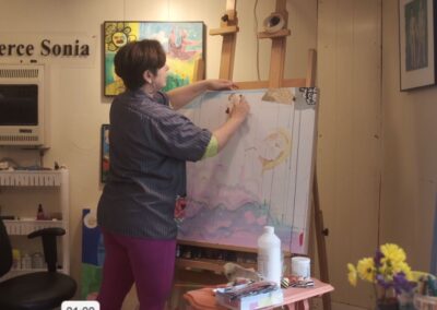 Artist Fierce Sonia sketching out a piece on an easel in her studio